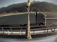 クレイジーってレベルじゃねーぞ・・・。並走するトラックの間で綱渡り・・・。