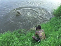 無茶するカメラマン。野生のワニの躍動的な姿を撮影しようと極限まで近づく