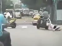 後部座席から落ちて引きずられている女の子に気づかずに走り続けるスクーター